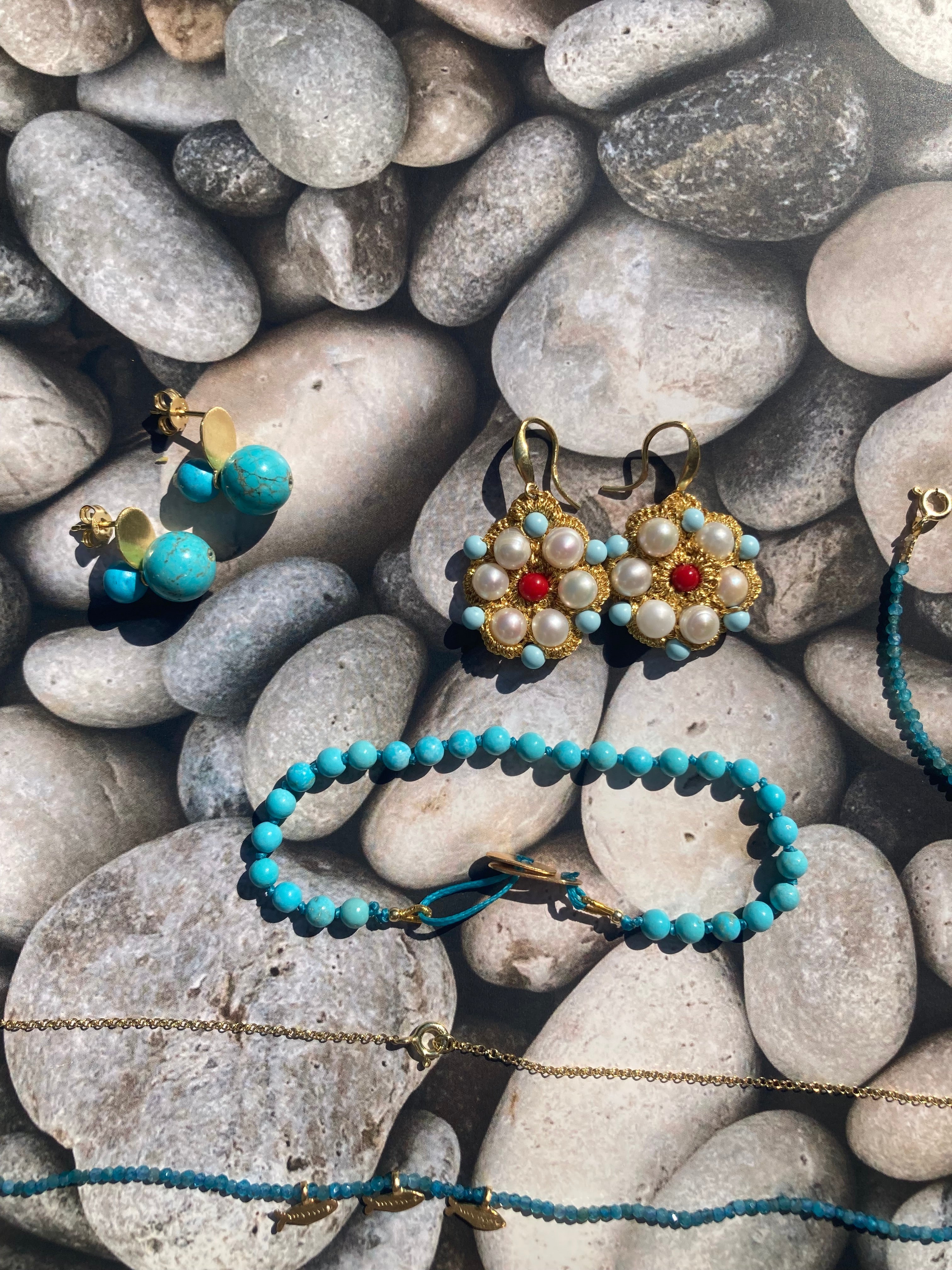 Bijoux de Méditerranée en Turquoise, argent, or , perle, corail sur fond de galets