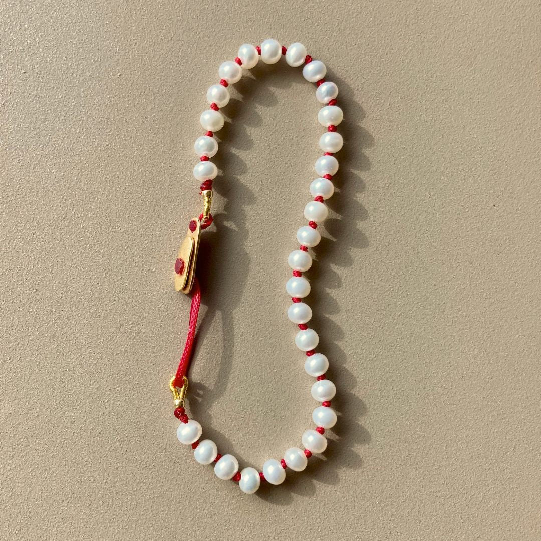 KImolos-bracelet_artisanal_Mymosaa_en_perles_etcordon_rouge_or__argent_sur_fond_neutre