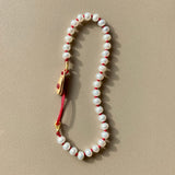 KImolos-bracelet_artisanal_Mymosaa_en_perles_etcordon_rouge_or__argent_sur_fond_neutre