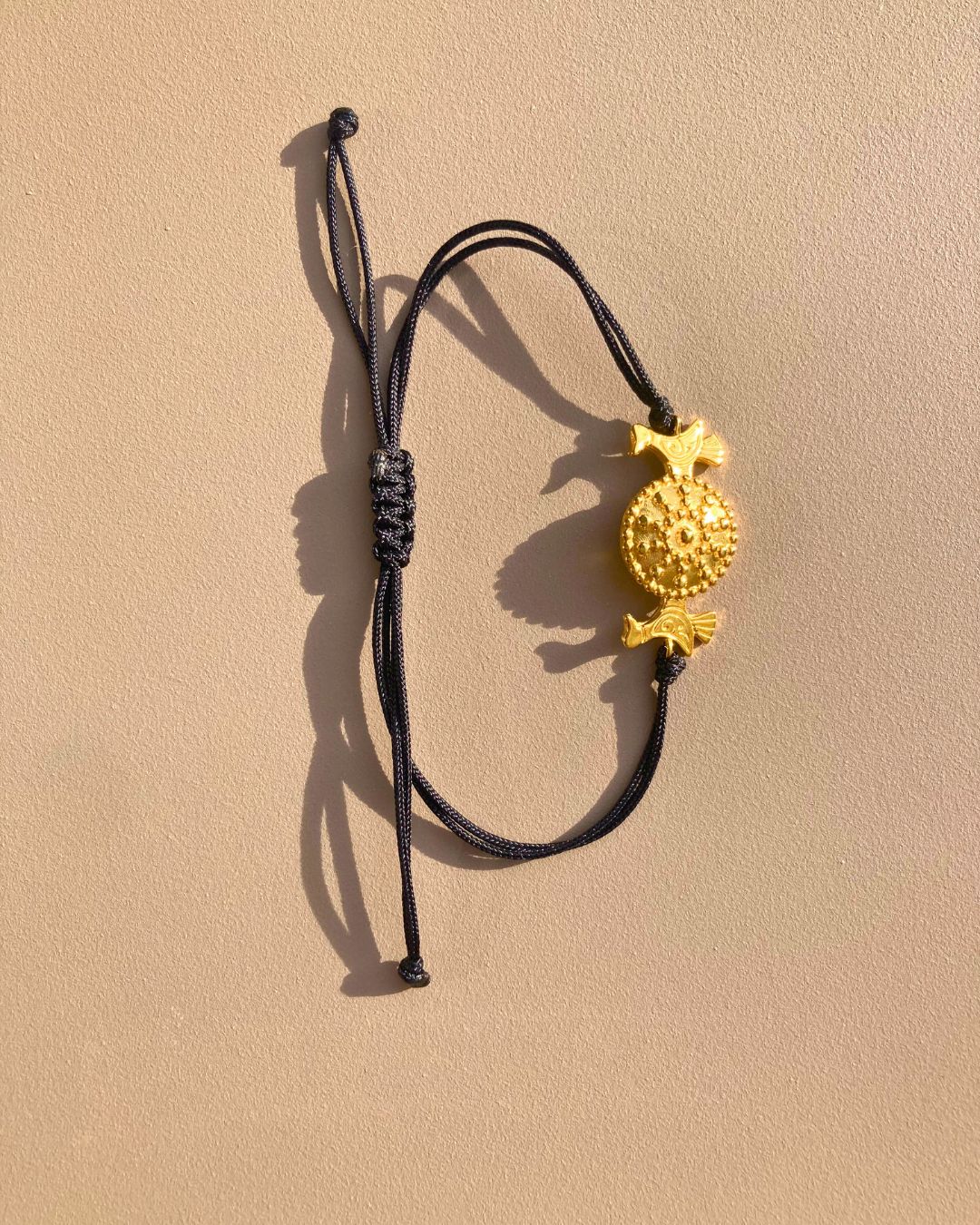 OFRYNIO_bracelets_avec_medaillon_en_argent_et_or_porte_bonheur_avec_cordon_ajustable_noir_sur_fond_neutre