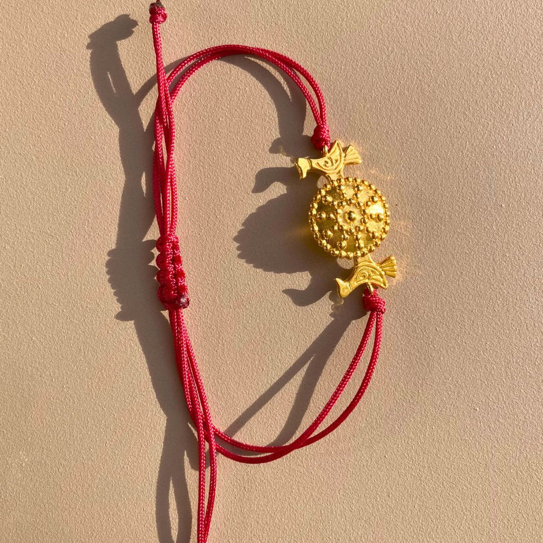 OFRYNIO_bracelets_avec_medaillon_en_argent_et_or_porte_bonheur_avec_cordon_ajustable_rouge_sur_fond_neutre